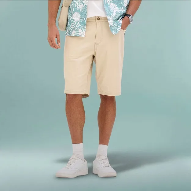 Avslappnad sommaroutfit med beige bermudashorts, m&ouml;nstrad skjorta och vita sneakers.


