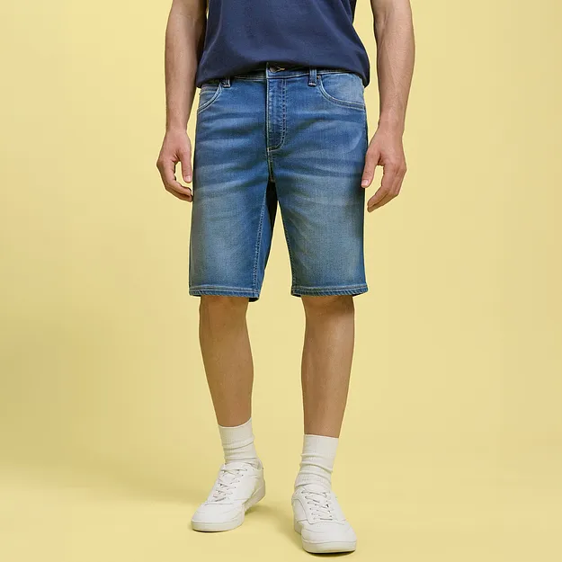 Avslappnade jeansshorts och bl&aring; T-shirt kombinerat med vita sneakers och strumpor.

