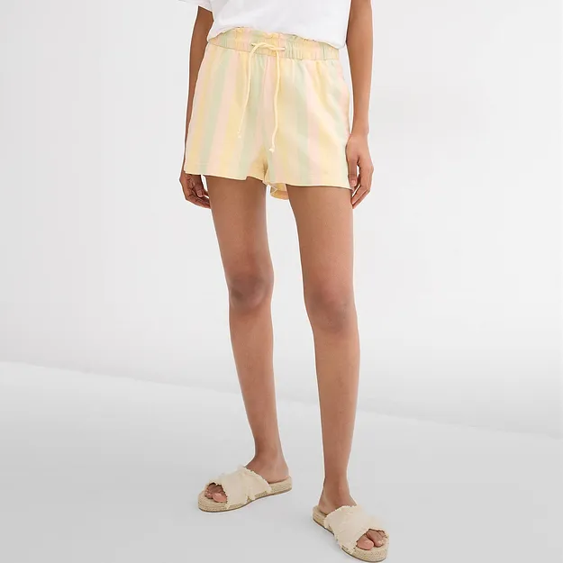 Randiga pastellshorts, vit T-shirt och bekv&auml;ma sandaler i bast f&ouml;r varma dagar.