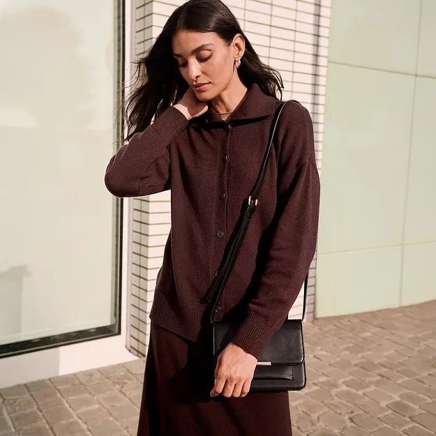 Elegant, brun cardigan med krage och knappsl&aring; och en svart v&auml;ska.