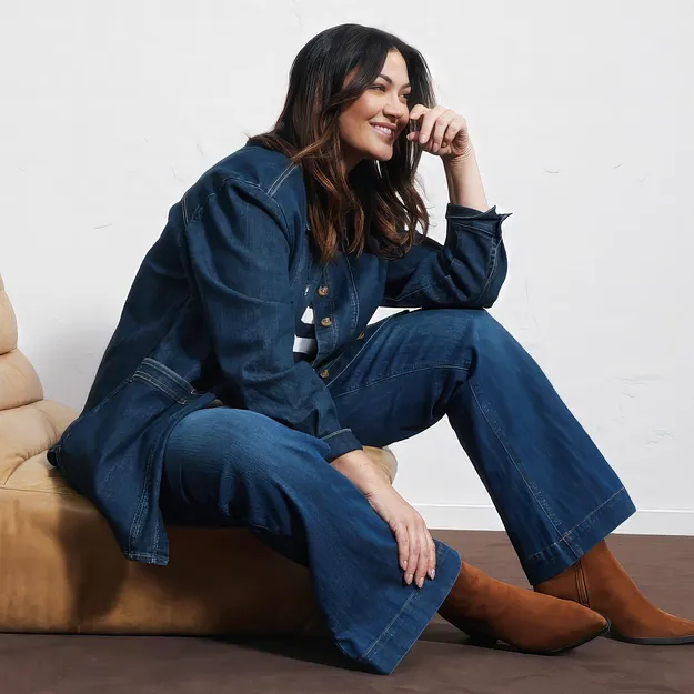 Stilfull look helt i denim: jeansjacka, vid byxa och eleganta, bruna st&ouml;vlar.