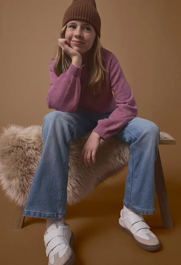 Brun m&ouml;ssa, rosa tr&ouml;ja, bl&aring;a jeans och vita sneakers med kardborreband.