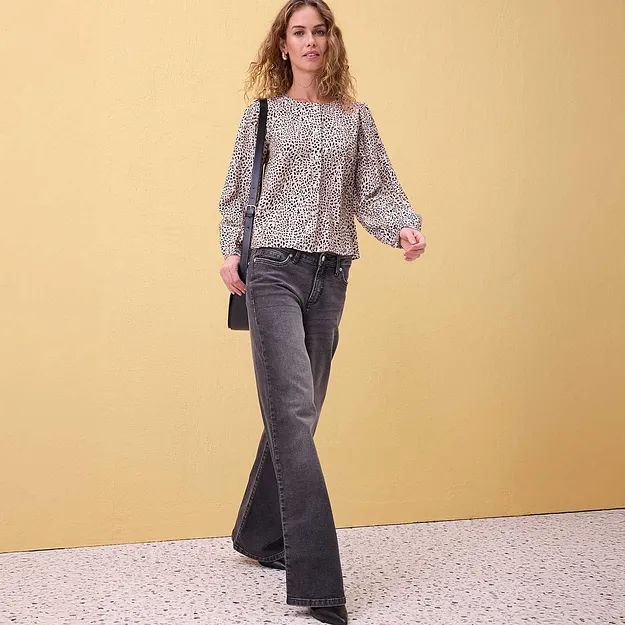 L&auml;tt, m&ouml;nstrad blus med puff&auml;rmar, kombinerad med utsv&auml;ngda gr&aring; jeans.

