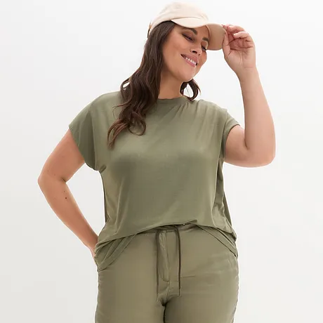 Olivgrön T-shirt och matchande byxor, kompletterat med en beige keps.
