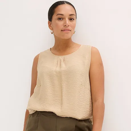 Enkel beige topp med rund halsringning, elegant och luftig för varma dagar.
