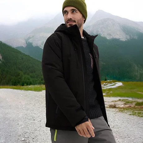 Svart jacka och grön mössa för den perfekta vinterlooken.

