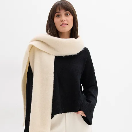 Svart tröja kombinerad med cremefärgad halsduk.

