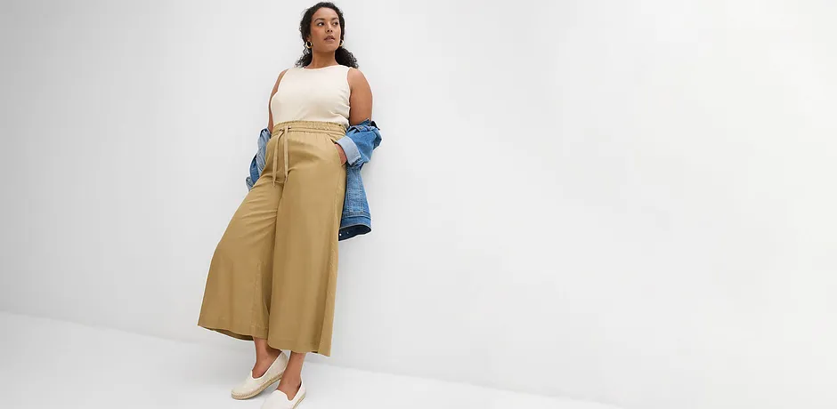 Avslappnad sommarlook: Vida beige byxor, vit topp och en blå jeansjacka.