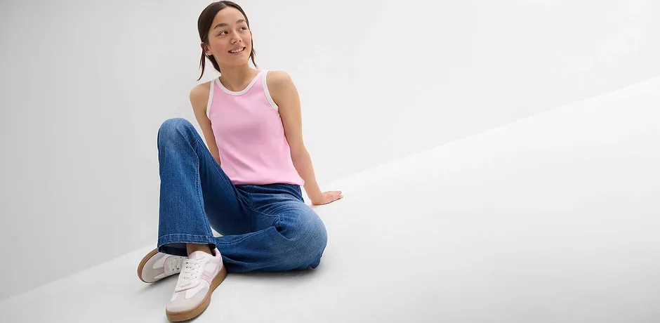 Rosa Tanktop, weite Jeans und weiße Sneakers - lässiger Sommerlook für entspannte Tage.