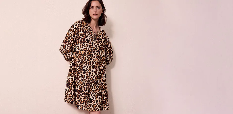 En luftig klänning med leopardmönster som sitter löst över axlarna och slutar strax ovanför knät.