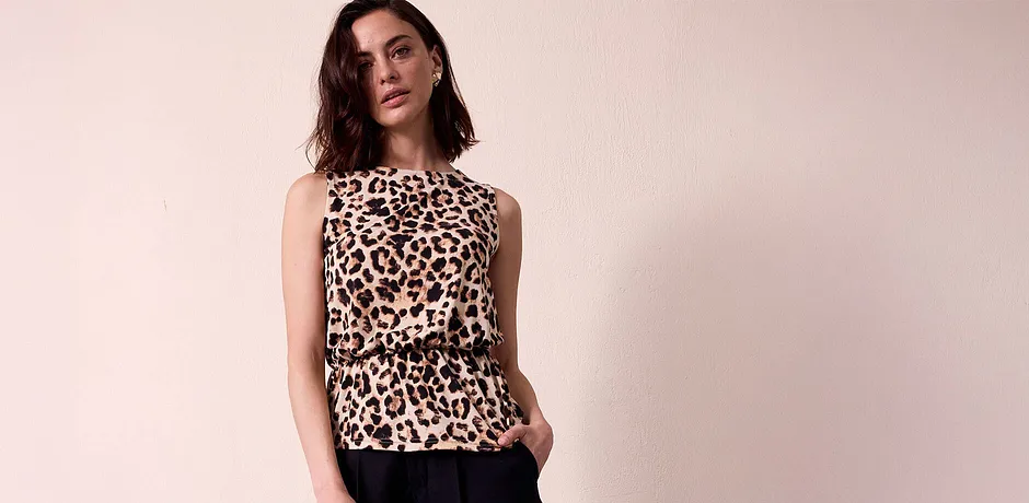 Ärmlös blus med leopardmönster, elegant och snygg. Svarta byxor som kontrast till det vilda mönstret.