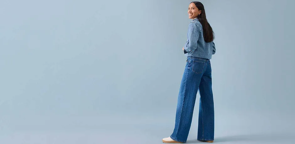 Ljusblå blus kombinerad med vida jeans.