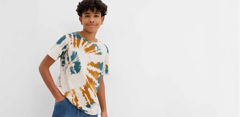 Modern batik T-shirt i blått och orange, kombinerad med klassiska jeans för en avslappnad look.