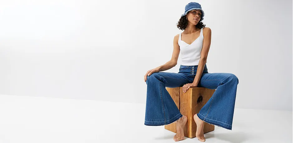 Vida jeans, vitt linne och blå hatt: en ledig sommarlook för varma dagar.