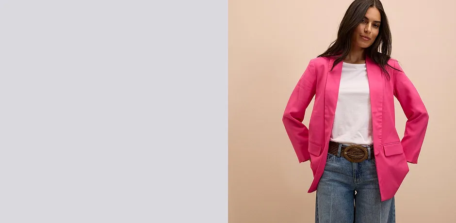 Knallrosa kavaj över en vit T-shirt, kombinerad med klassiska jeans och brunt skärp.