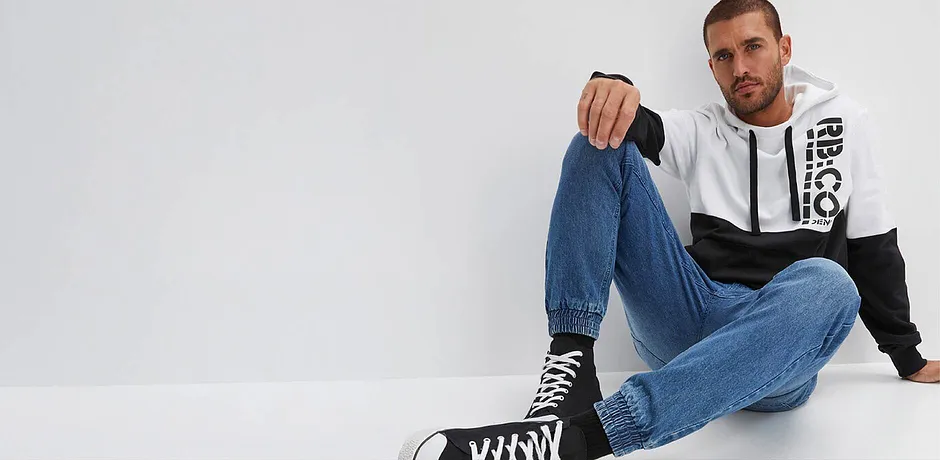 Avslappnad look med jeans, tvåfärgad hoodie och höga sneakers.

