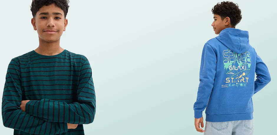 En randig grön-svart tröja med långa ärmar och en blå hoodie med färgglatt rymdtryck på ryggen.