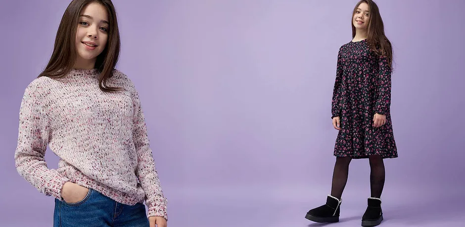 En mysig stickad tröja i rosa toner och en blommig klänning med långa ärmar, svarta strumpbyxor och mysiga boots.

