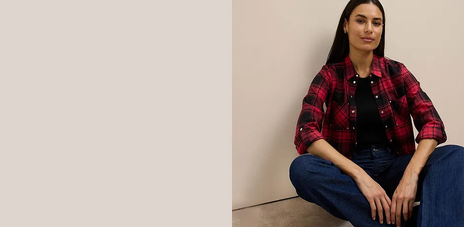 Röd/svart rutig skjortblus över svart linne kombinerad med klassiska jeans.