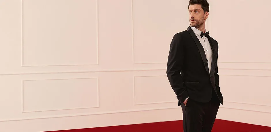 Elegant svart smoking med vit skjorta och fluga för festliga tillfällen.

