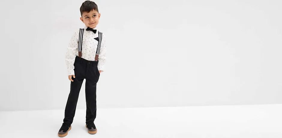 Pojken bär skjorta och fluga.

