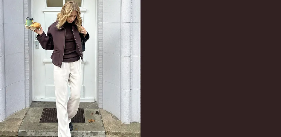 Avslappnad look med mörk jacka och ljusa byxor.

