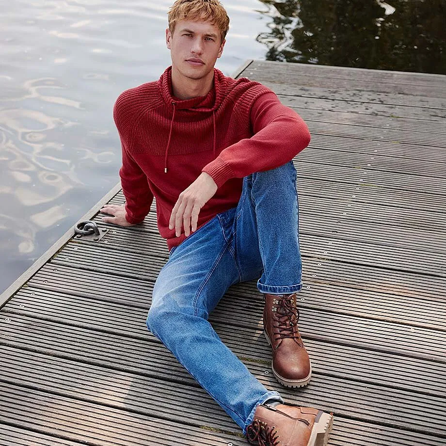 R&ouml;d hoodie tillsammans med bl&aring; jeans och bruna k&auml;ngor.