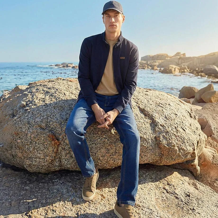 Bl&aring; jacka, beige tr&ouml;ja och jeans f&ouml;r soliga dagar vid havet.

