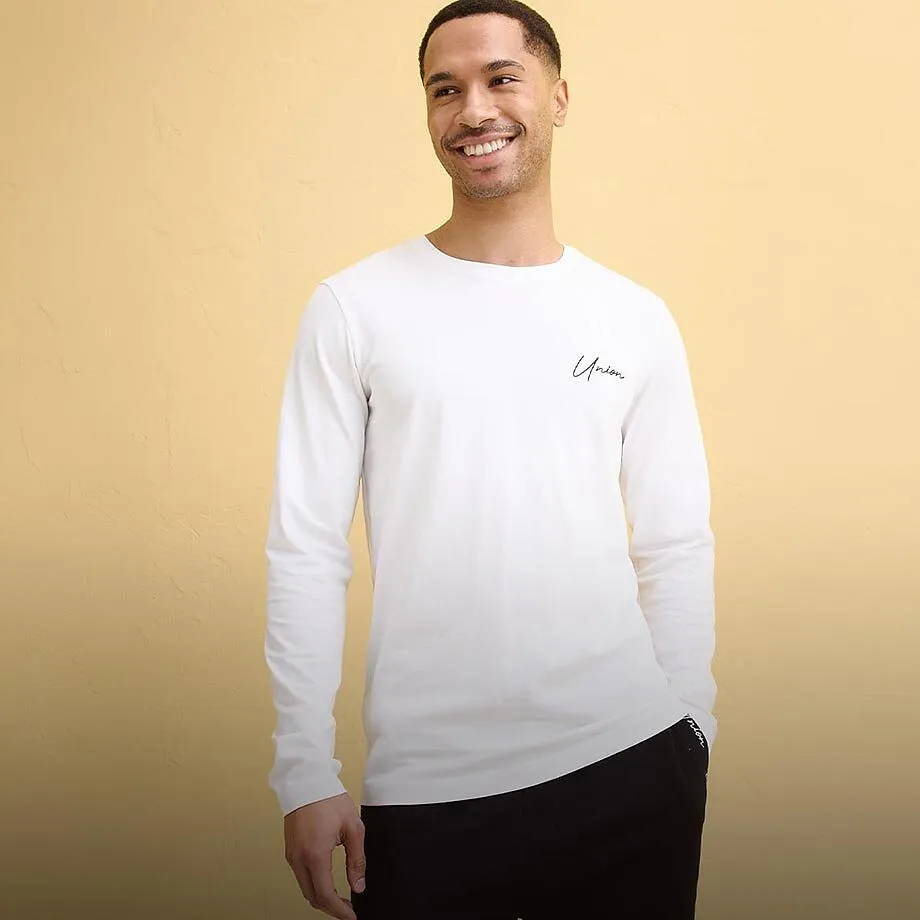 Enkel vit l&aring;ng&auml;rmad tr&ouml;ja med liten logotyp.

