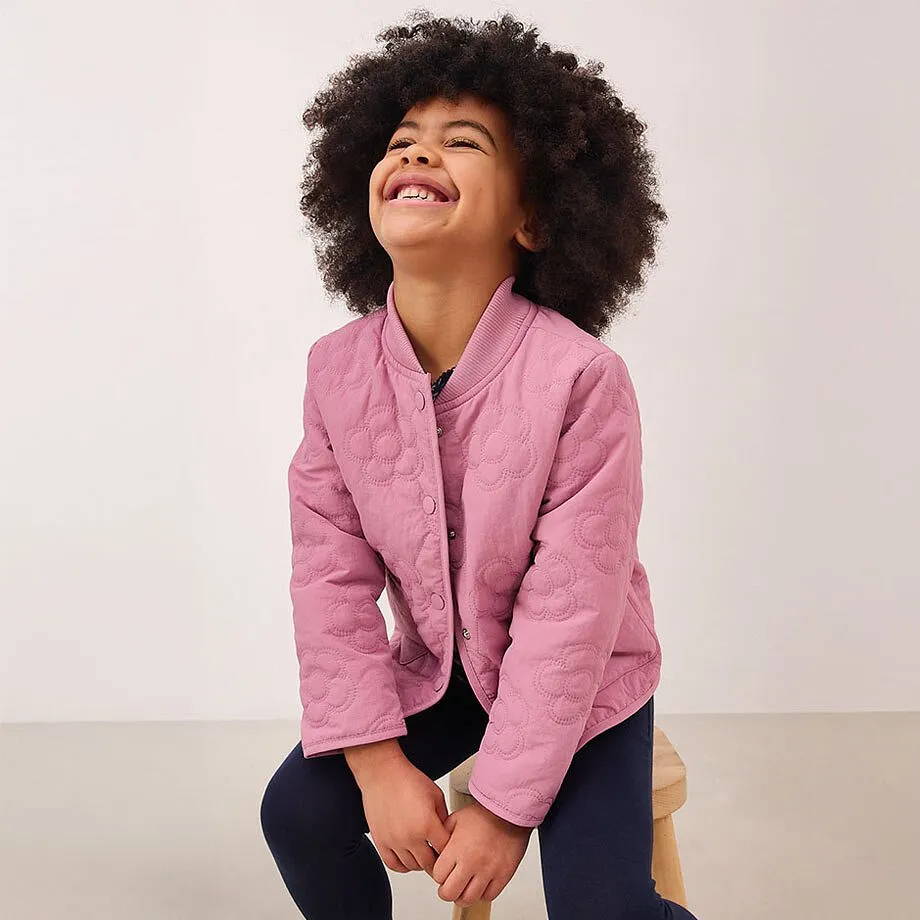 En rosa jacka med knappar &ouml;ver en m&ouml;rk topp.

