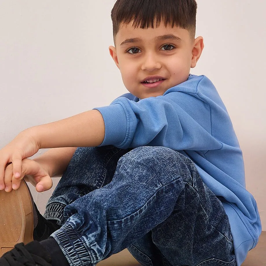 Bl&aring; tr&ouml;ja och jeans skapar en avslappnad look f&ouml;r ungt mode.

