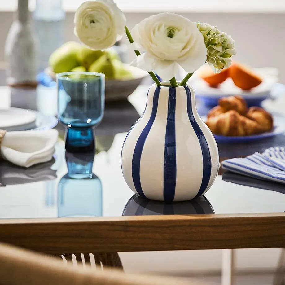 En randig vas med blommor.