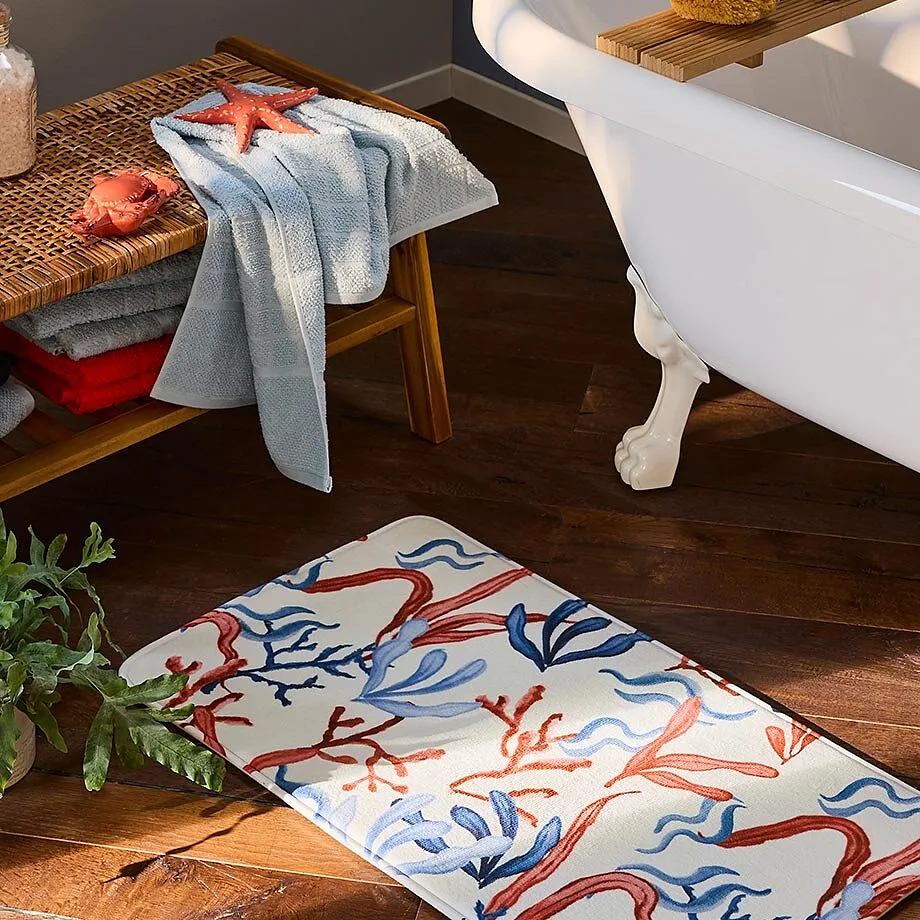 En ljusbl&aring; handduk ligger p&aring; en tr&auml;b&auml;nk bredvid ett frist&aring;ende badkar.

