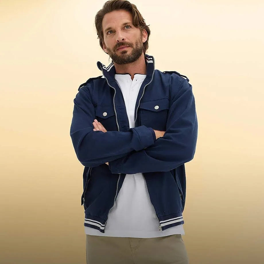 M&ouml;rkbl&aring; jacka med vita detaljer &ouml;ver en stilren, vit T-shirt.