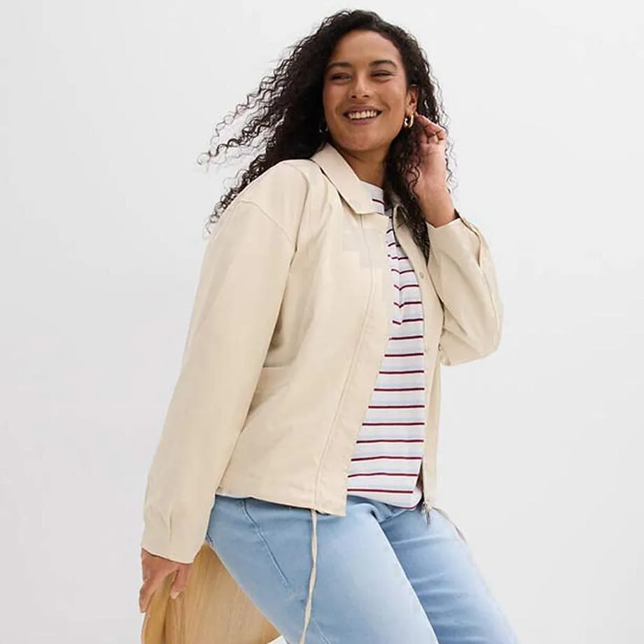 Cremef&auml;rgad jacka &ouml;ver en randig topp