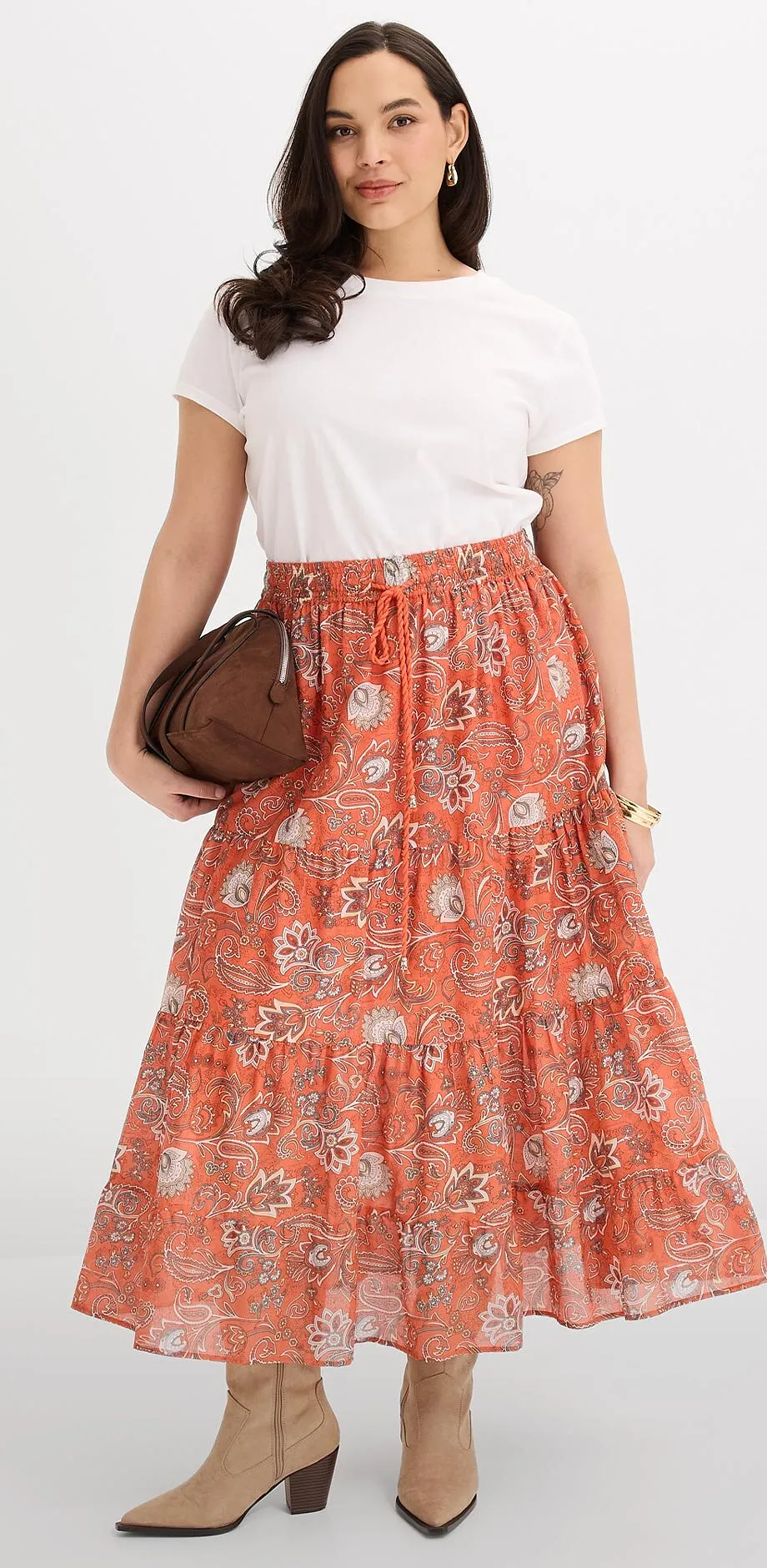 Vit T-shirt kombinerad en orange, m&ouml;nstrad maxikjol.