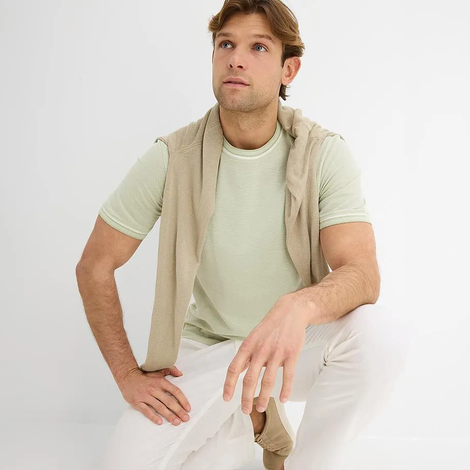 Ljus t-shirt med l&auml;tt tr&ouml;ja och vita byxor.

