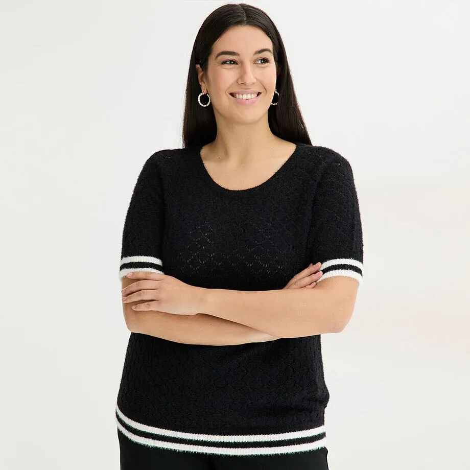 Svartvit ajourstickad tr&ouml;ja med fj&auml;dergarn.

