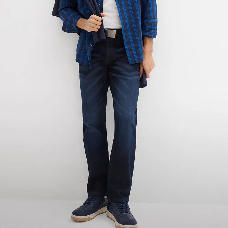 Rutig skjorta, m&ouml;rka jeans och matchande skor i marinbl&aring;tt.