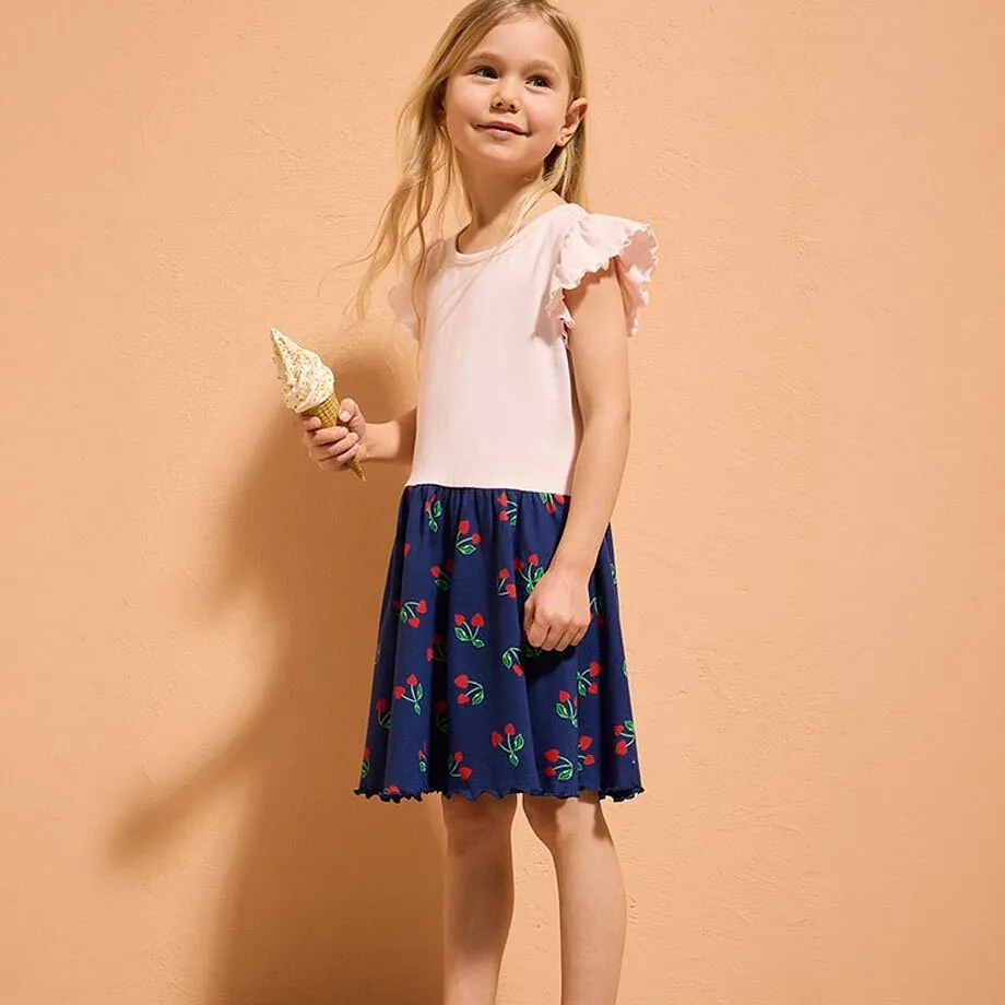 T-shirt med volanger och m&ouml;rkbl&aring; kjol med f&auml;rgglatt m&ouml;nster.

