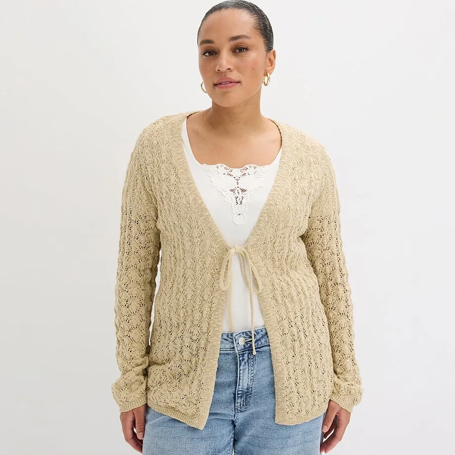 Beige cardigan &ouml;ver vit topp kombinerat med klassiska bl&aring; jeans.


