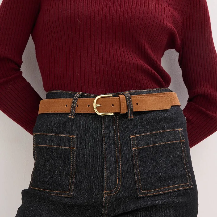 Stickad tr&ouml;ja med jeans och brunt l&auml;derb&auml;lte.

