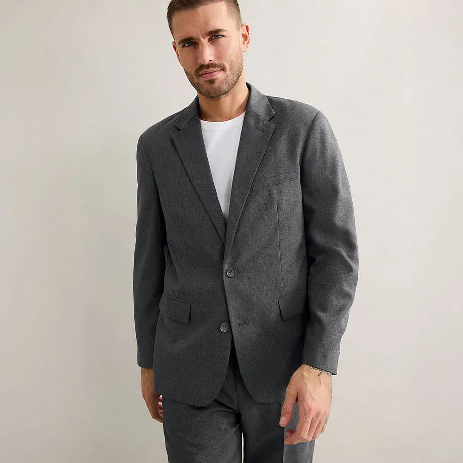 Elegant gr&aring; kostym med en enkel vit t-shirt under.

