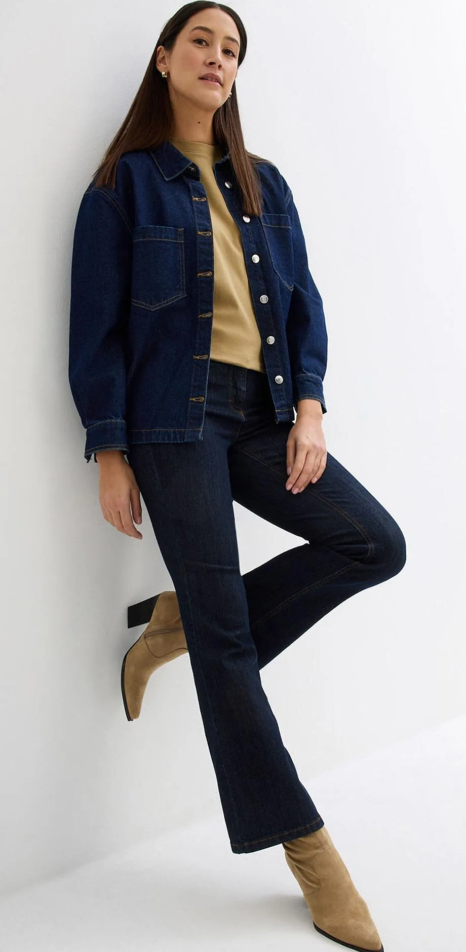 M&ouml;rkbl&aring; jeansjacka och jeans, beige tr&ouml;ja och spetsiga st&ouml;vletter.

