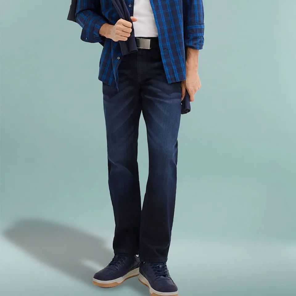 Rutig skjorta, m&ouml;rka jeans och matchande skor i marinbl&aring;tt.