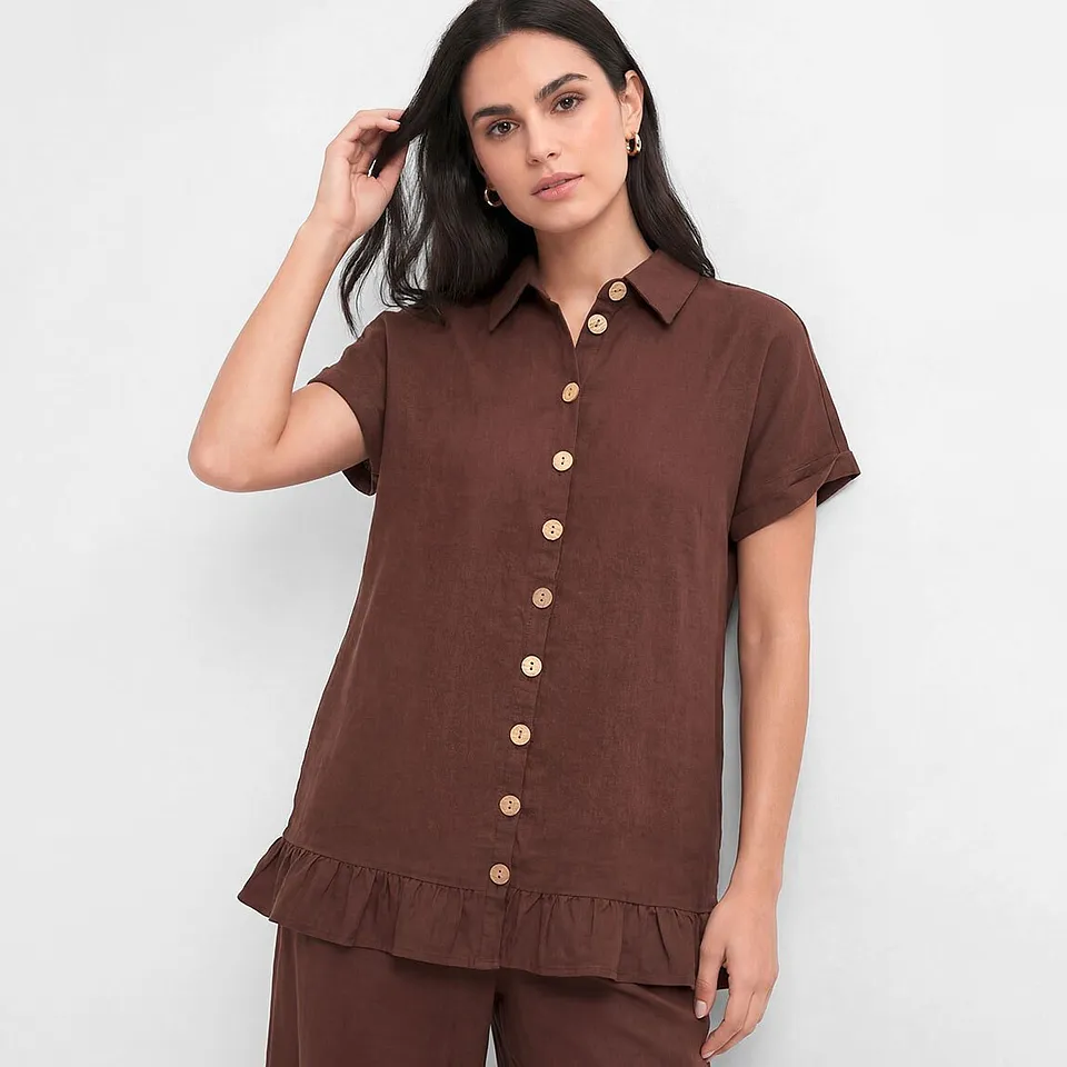 Brun blus med korta &auml;rmar och ljusa knappar.