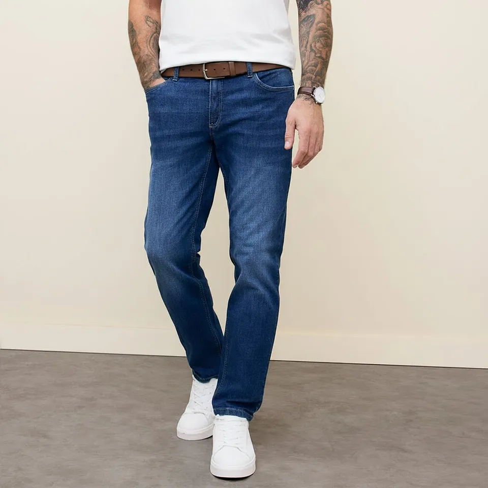 Klassisk look med en vit t-shirt, bl&aring;a jeans, ett brunt sk&auml;rp och vita sneakers.

