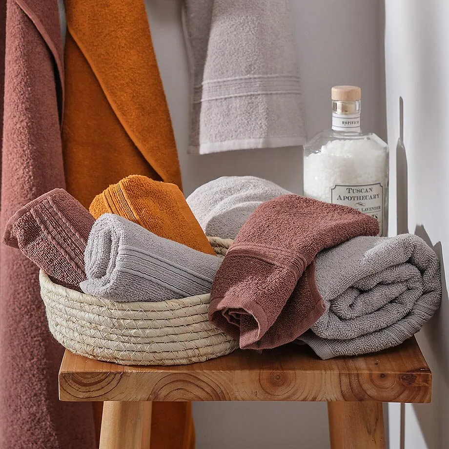 Mysiga handdukar i varma toner &ndash; orange, beige och gr&aring; perfekt kombinerade.