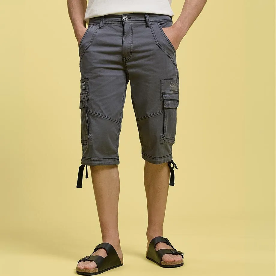 Gr&aring;a cargoshorts med praktiska sidfickor, vit T-shirt och svarta tofflor.

