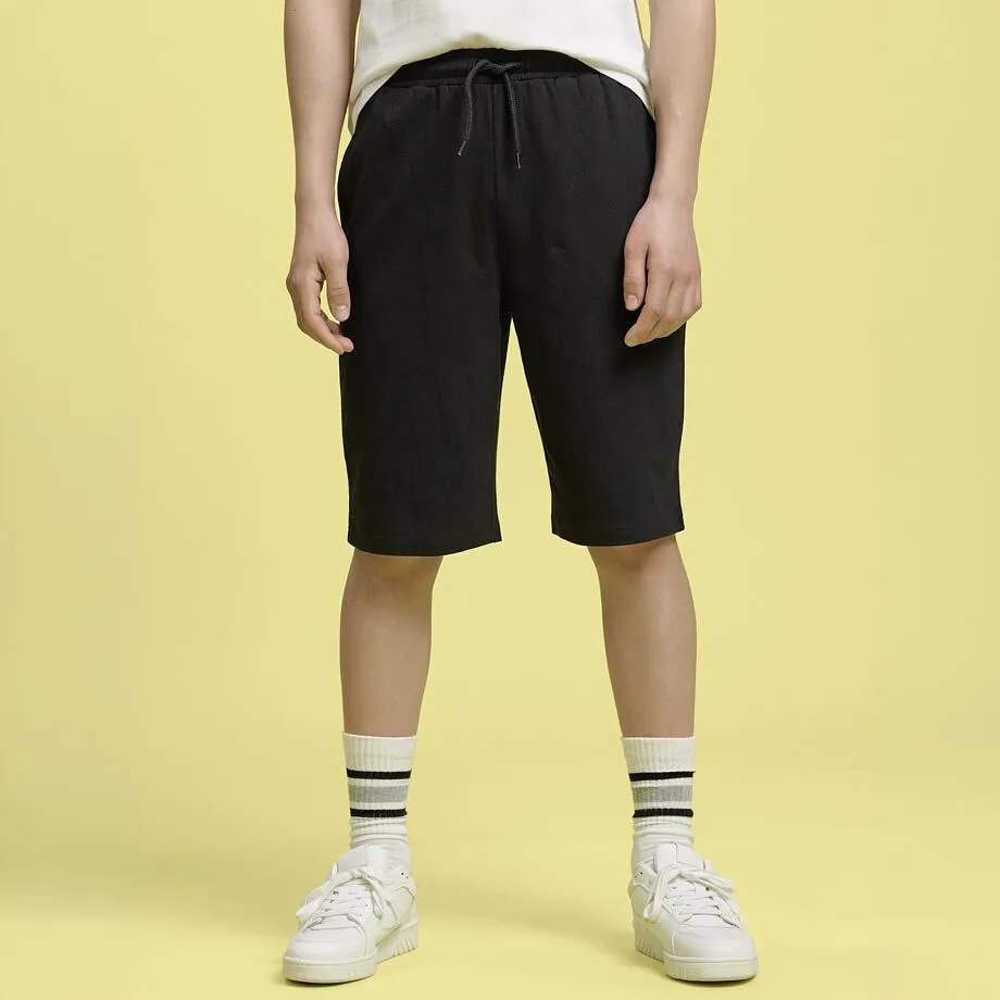 Outfit med vit T-shirt och svarta shorts.

